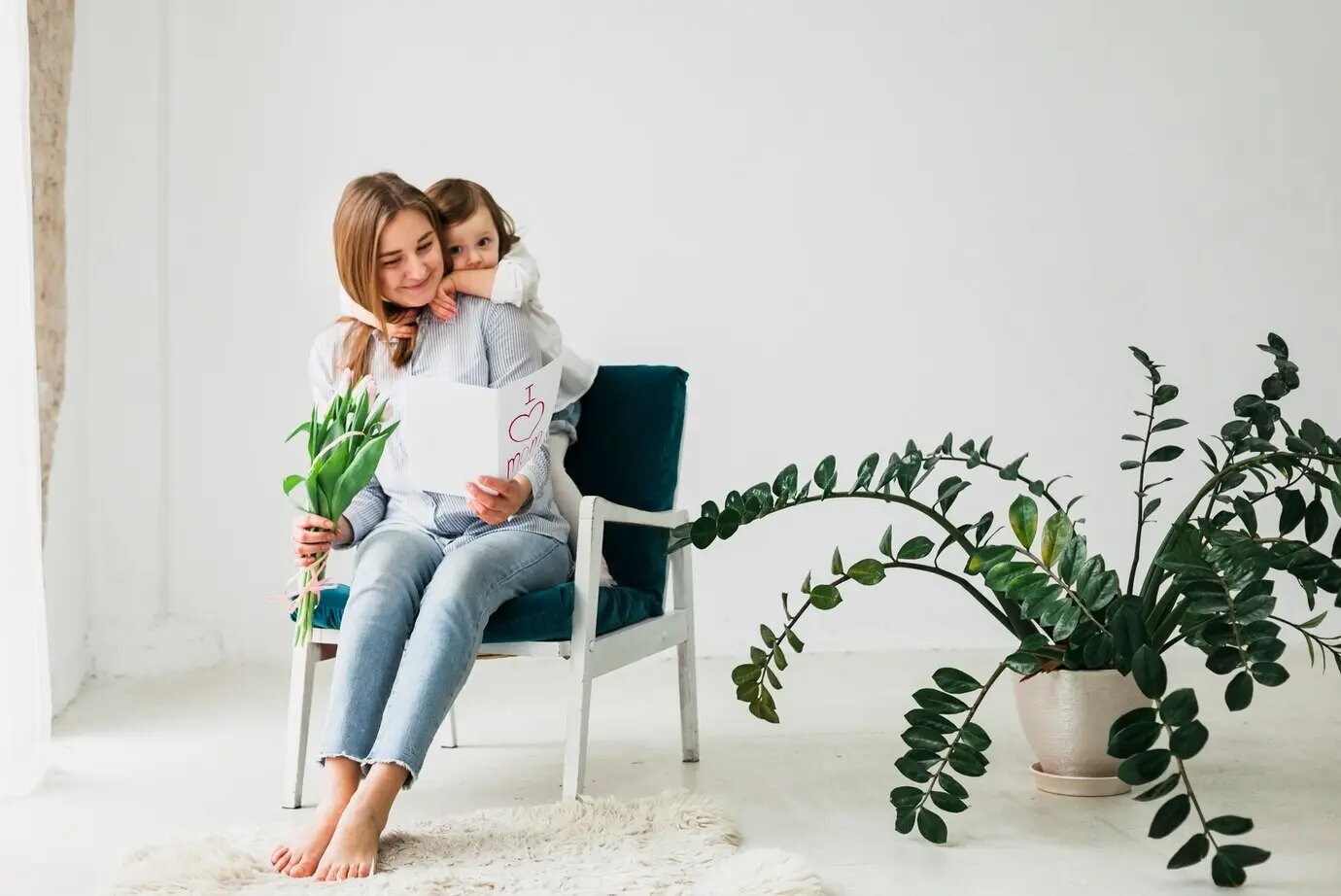 Eine Tochter umarmt ihre Mutter mit einer Grußkarte.