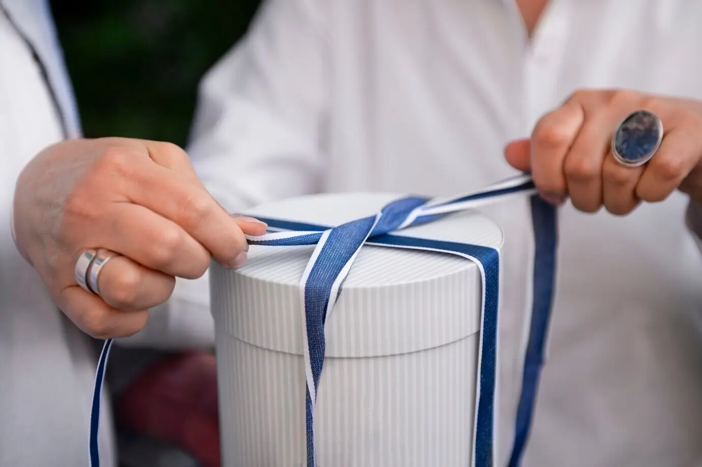 Frontalansicht einer Frau, die ein Geschenk öffnet.